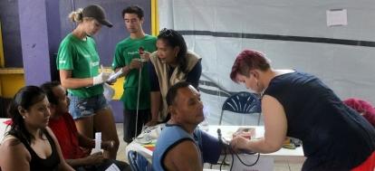 Public Health volunteer measuring the blood pressure of a local man Volunteers doing free health screenings at the health fair in Belize